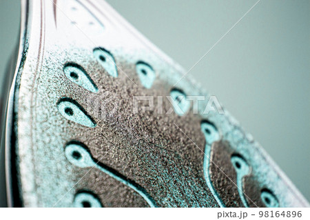Iron with traces of burnt fabric. Melted fabric on the sole of the iron. 98164896