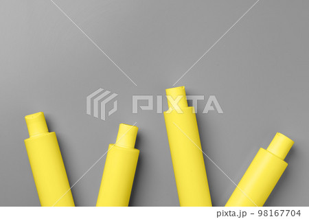 Yellow cosmetic container on gray background top view 98167704