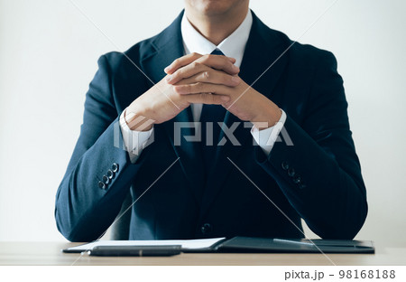 手を組んで話を聞くビジネスマン 手を組んで話を聞くビジネスマン 98168188