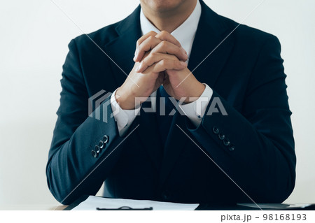 手を組んで話を聞くビジネスマン 手を組んで話を聞くビジネスマン 98168193