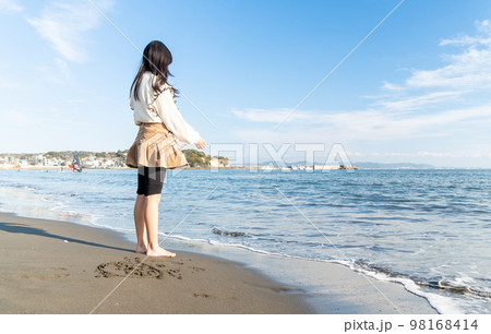冬の海辺で海を見つめる10代の若い女性 冬の海辺で海を見つめる10代の若い女性 98168414