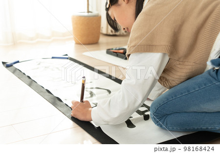 書き初めを書く日本人の小学生の女の子 98168424