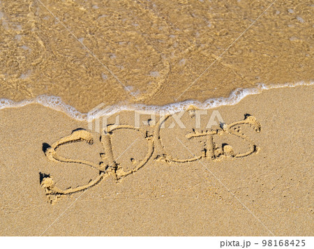 綺麗な海の砂浜の波打ち際に書かれた「SDGs」の文字。 98168425