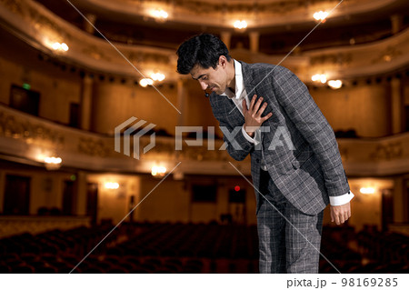 man Presenter on Stage is expression gratitude to audience after performance. 98169285