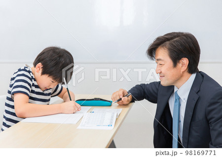小学生に授業で勉強・漢字を教える笑顔の個別指導の塾講師・先生（日本人男性） 98169771