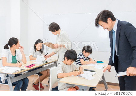 学習塾で小学生に勉強を教えるアジア人塾講師・先生(夏期講習) 学習塾で小学生に勉強を教えるアジア人塾講師・先生(夏期講習) 98170676