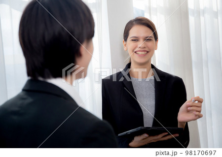 Young manager talking with secretary about report marketing on digital tablet for planning. 98170697