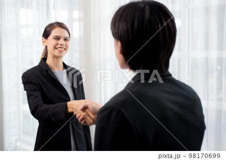 Happy business man and woman standing and shake hands while agreement of negotiation. Happy business man and woman standing and shake hands while agreement of negotiation. 98170699