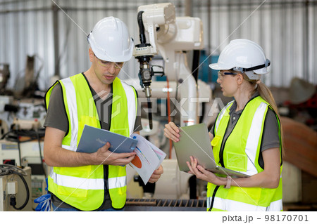 Engineer man and woman talking and explaining about robot arms technology intelligence. 98170701