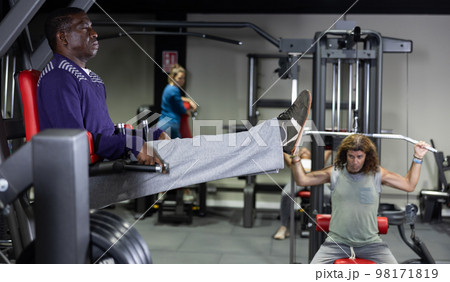 African american athlete pulls his legs to his chest on special simulator African american athlete pulls his legs to his chest on special simulator 98171819