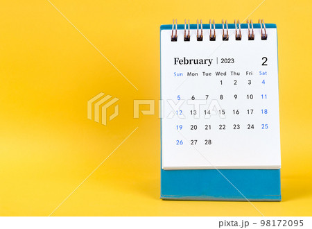 The February 2023 desk calendar on yellow color background. 98172095