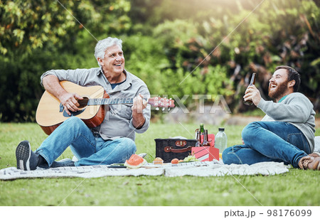 Guitar, father and son on park picnic with beer and music during holiday in Australia in summer. Senior dad and man laughing at comic sound on instrument while happy on vacation in a nature garden Guitar, father and son on park picnic with beer and music during holiday in Australia in summer. Senior dad and man laughing at comic sound on instrument while happy on vacation in a nature garden 98176099