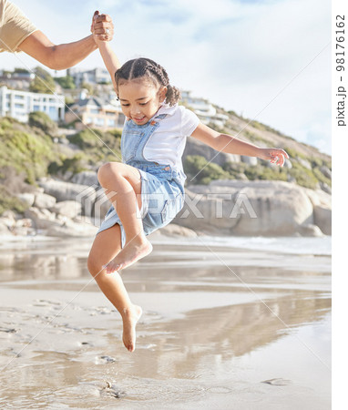 Summer, family and girl at the beach with arm of dad lifting her in water, having fun and bonding on travel vacation. Love, happy and ocean wave by child and parent playing in sea, happy and relax 98176162