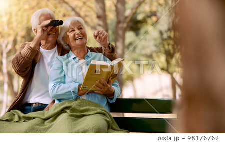 Love, senior couple and watching birds with book, binocular and romantic together. Romance, mature man and elderly woman in nature, happy and talking about animals, notebook and park bench for hobby. 98176762