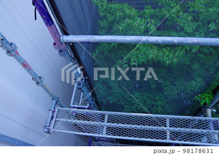 戸建て住宅の外壁塗装　屋根塗装　現場　足場の組まれた家　塗装工事　足場　住宅工事の様子　養生 98178631