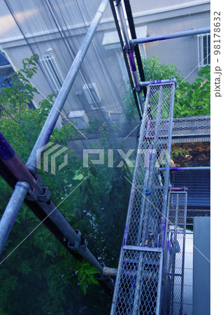 戸建て住宅の外壁塗装　屋根塗装　現場　足場の組まれた家　塗装工事　足場　住宅工事の様子　養生 98178632