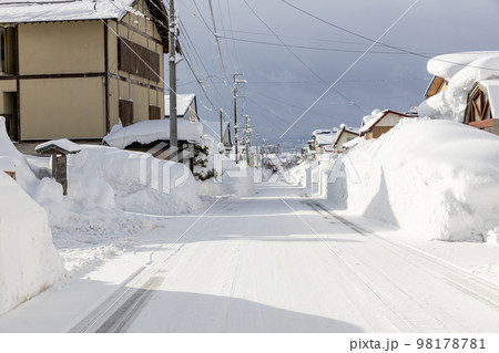 大雪の集落の道路 98178781