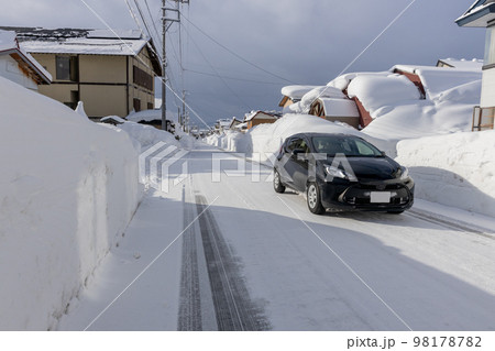 大雪の集落の道路 98178782