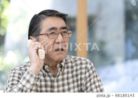 不審な電話に出るシニア男性 98180143
