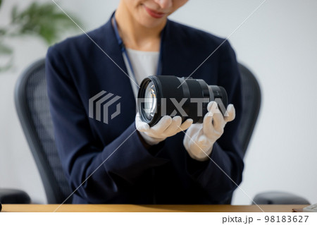 カメラのレンズを査定する女性 98183627