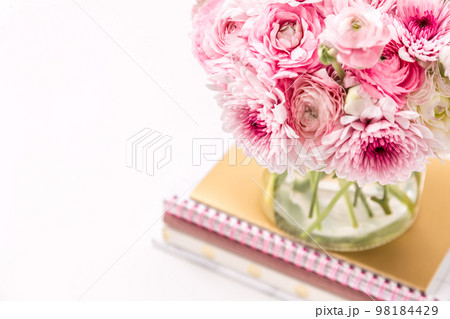 Feminine desktop with gold and pink stationery including fresh flowers 98184429