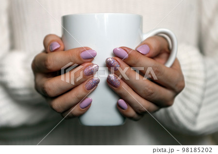 Manicured Womans Hands Holding Cup. trendy pastel color nails. Spring summer design. beauty salon 98185202