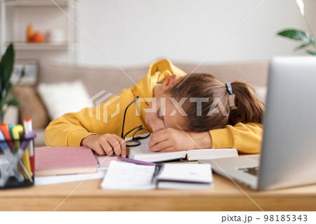 Little girl fell asleep while studying at home 98185343