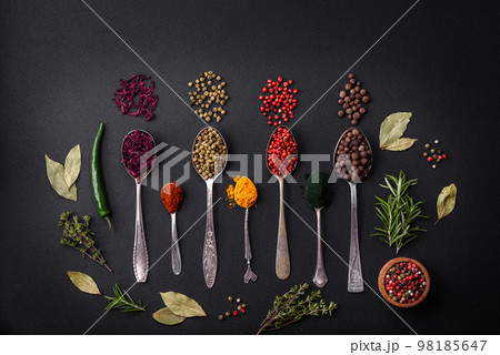 Several types of spices in metal spoons paprika, tomatoes, curry, beets, cumin, turmeric, fennel, spirulina 98185647