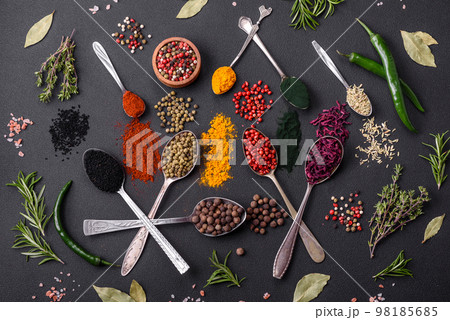 Several types of spices in metal spoons paprika, tomatoes, curry, beets, cumin, turmeric, fennel, spirulina 98185685