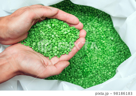 hands hold or touching biodegradable plastic pellets, plastic polymer granules 98186183