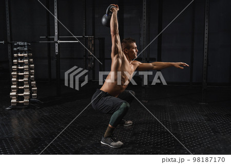 Kettlebells swing exercise man workout at gym. Crossfit training Kettlebells swing exercise man workout at gym. Crossfit training 98187170