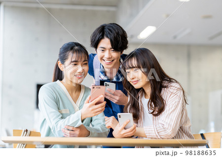 スマホを見る大学生の男女 98188635
