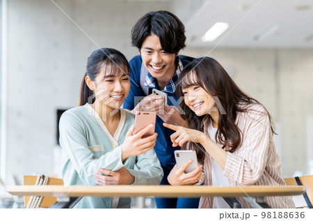 スマホを見る大学生の男女 98188636
