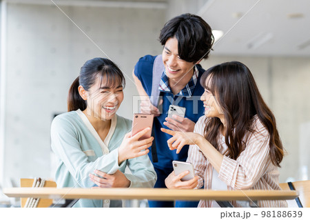 スマホを見る大学生の男女 98188639