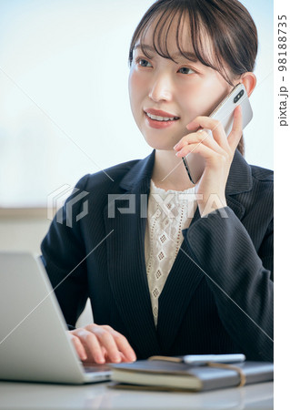 デスクで電話をする若い女性 98188735