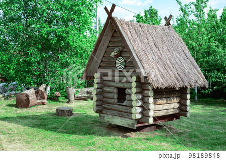 A wooden hut on a green lawn among the trees on the territory of 98189848
