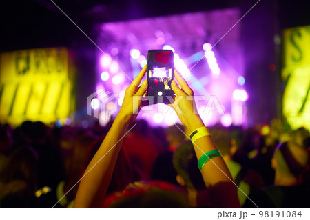 Hand with a phone records live music festival. People taking photographs with smart phone during concert. Hand with a phone records live music festival. People taking photographs with smart phone during concert. 98191084