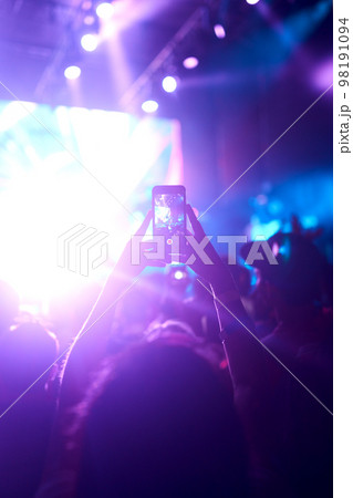 Hand with a phone records live music festival. People taking photographs with smart phone during concert. Hand with a phone records live music festival. People taking photographs with smart phone during concert. 98191094
