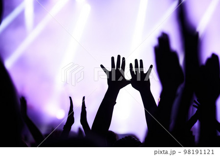 People taking photographs with smart phone during a music festival. Fans enjoying rock concert with light. People taking photographs with smart phone during a music festival. Fans enjoying rock concert with light. 98191121