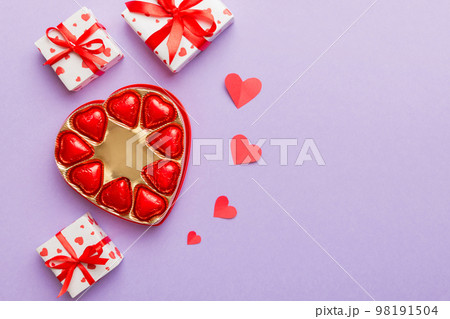 Delicious chocolate pralines in box for Valentine's Day. Heart shaped with gift box of chocolates top view with copy space Delicious chocolate pralines in box for Valentine's Day. Heart shaped with gift box of chocolates top view with copy space 98191504
