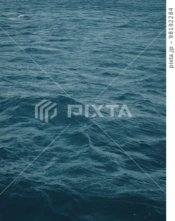 Vertical view of dark blue-green color of water surface with waves in middle of endless deep sea. Dark blue waves in deep ocean. Raging aquamarine waves on surface of the water. Vertical view of dark blue-green color of water surface with waves in middle of endless deep sea. Dark blue waves in deep ocean. Raging aquamarine waves on surface of the water. 98192284
