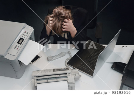 Stressed tired businesswoman feels exhausted sitting at office desk with laptop 98192616