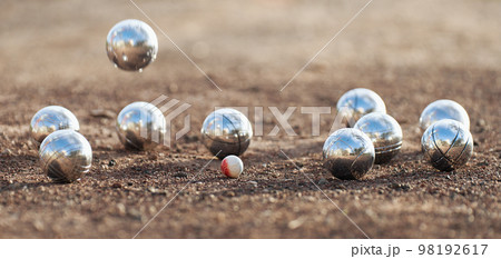 Petanque ball boules bowls on a dust floor, photo in impact. Game of petanque on the ground. Balls and a small wood jack Petanque ball boules bowls on a dust floor, photo in impact. Game of petanque on the ground. Balls and a small wood jack 98192617