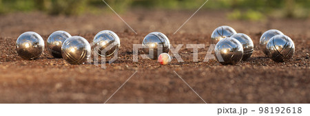 Petanque balls boules bowls on closeup on sand gravel court background, game of petanque on the ground. Balls and a small wood jack 98192618