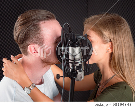 Portrait of young attractive men and women have fun laughing together in the sound recording studio.. Portrait of young attractive men and women have fun laughing together in the sound recording studio.. 98194343