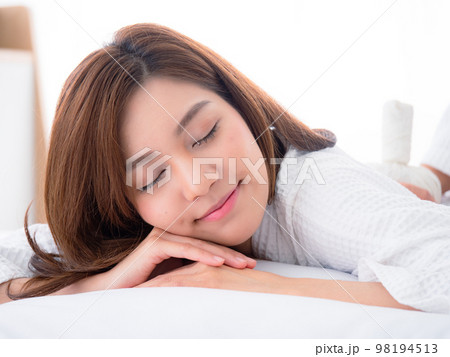 Beautiful young woman relaxing with closed eyes, waiting for massage in the home spa Beautiful young woman relaxing with closed eyes, waiting for massage in the home spa 98194513