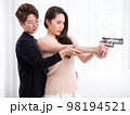 Young Asia LGBT teaches her girlfriend the backslider how to handle a weapon, firearm training at a firing range, in the bedroom 98194521