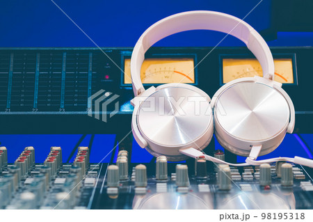 white headphone on audio mixing console. music background 98195318
