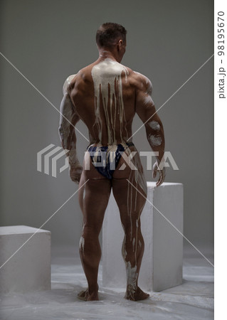 Sexy male back view of shirtless athletic strong man at studio 98195670