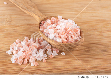 Pink Himalayan salt on wooden spoon and wooden background. Pink Himalayan salt on wooden spoon and wooden background. 98196475